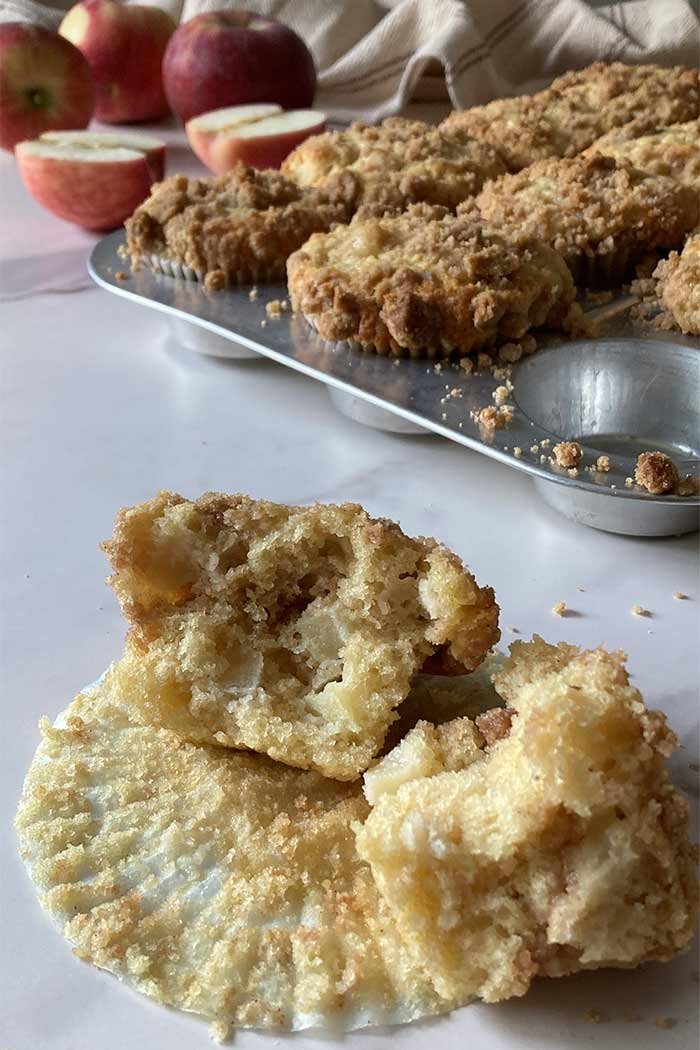 apple muffin with cinnamon streusel topping torn in half to see the tender crumb inside