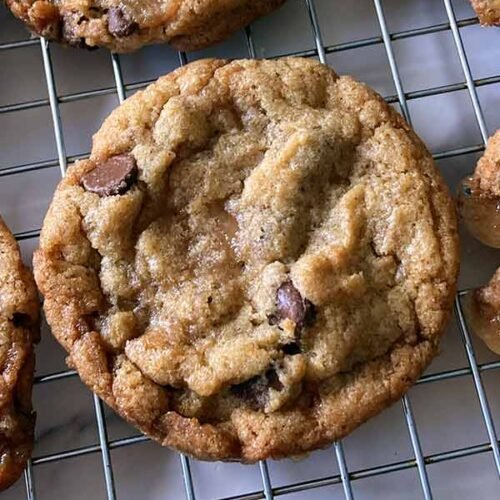 homemade brown butter toffee chocolate chip cookie on a wire cooling rack