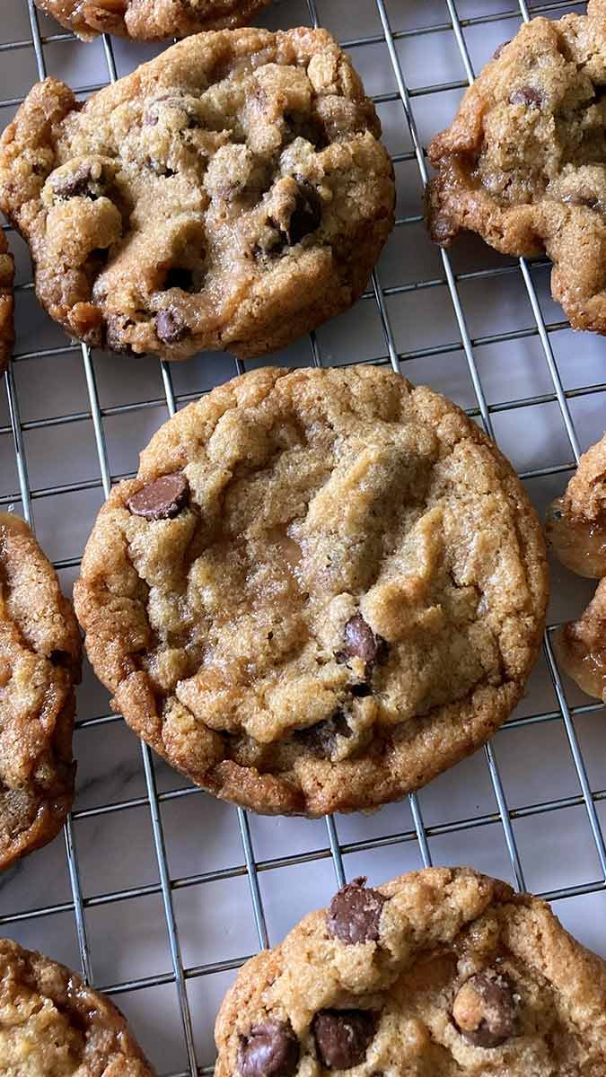 homemade brown butter toffee chocolate chip cookies on a wire cooling rack