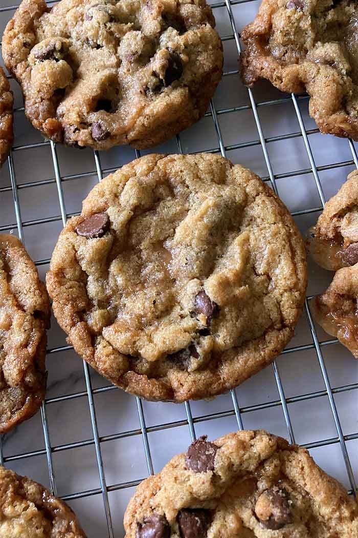 homemade brown butter toffee chocolate chip cookies on a wire cooling rack
