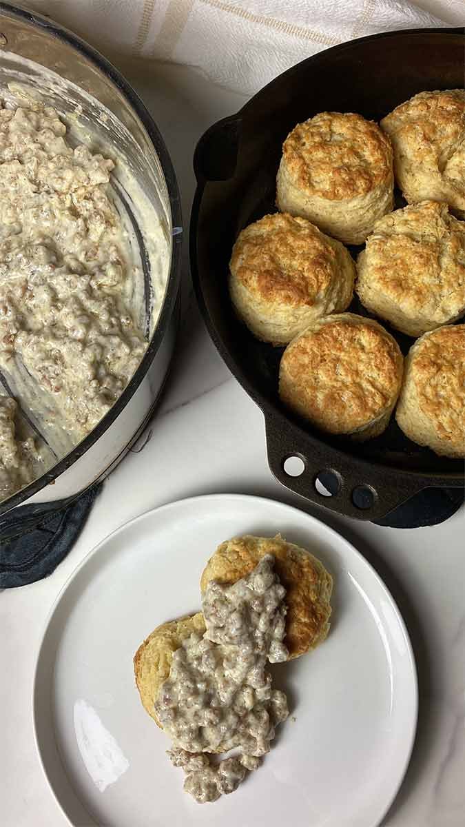 rich homemade sausage gravy poured over a plate of buttermilk biscuits