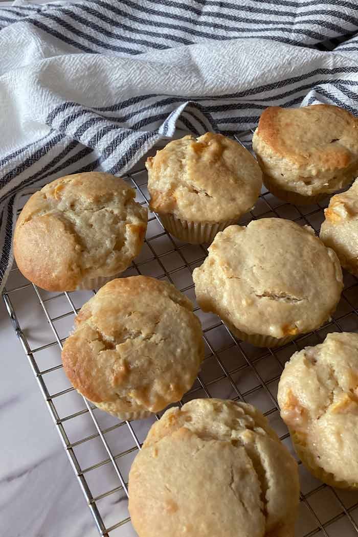 moist peaches and cream muffins on a cooling rack