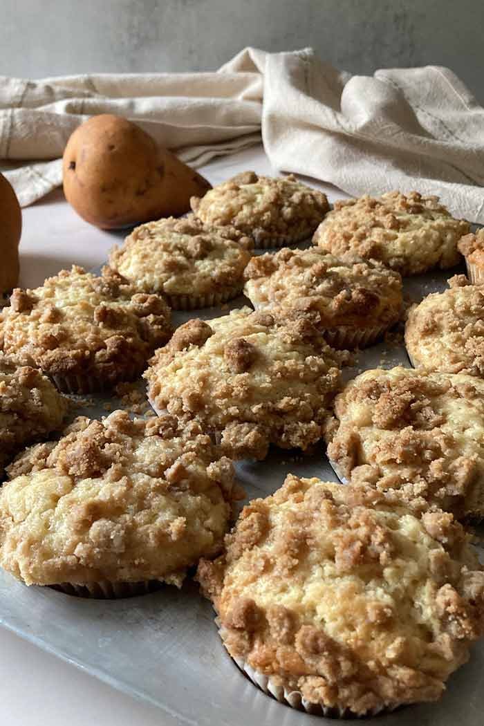 moist pear streusel muffins in a muffin pan