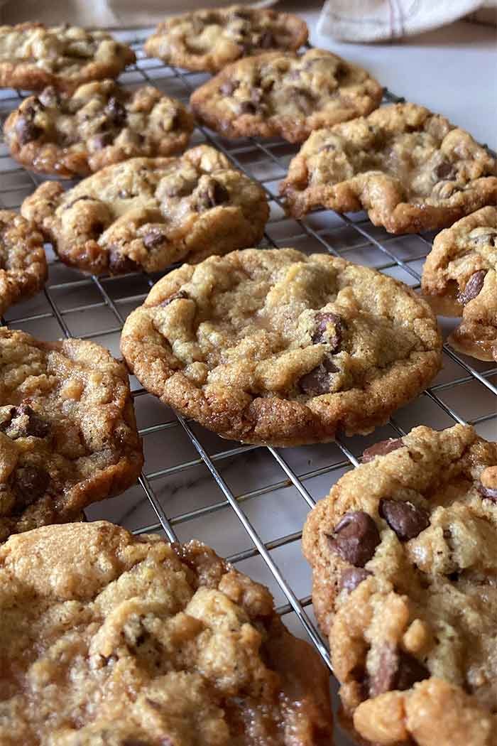 rows of golden, homemade brown butter toffee chocolate chip cookies on a cooling rack