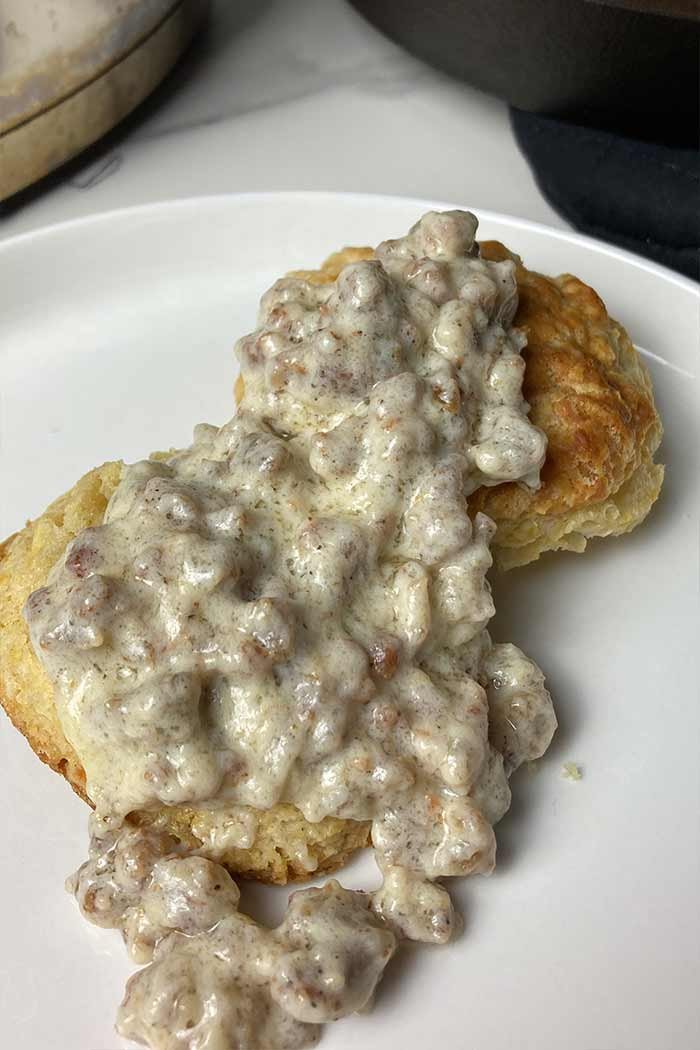 creamy breakfast sausage gravy poured over a homemade buttermilk biscuit