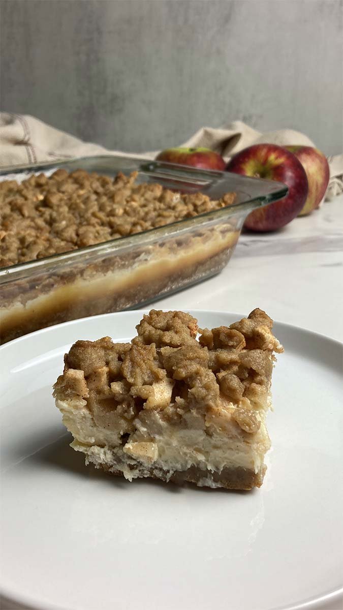 single slice of easy apple crumble cheesecake bar slice on plate