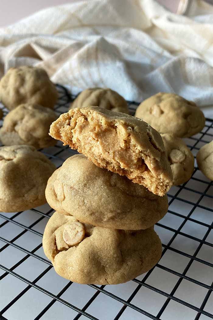 stack of ultimate peanut butter cookies with one broken open to see the peanut butter filling inside