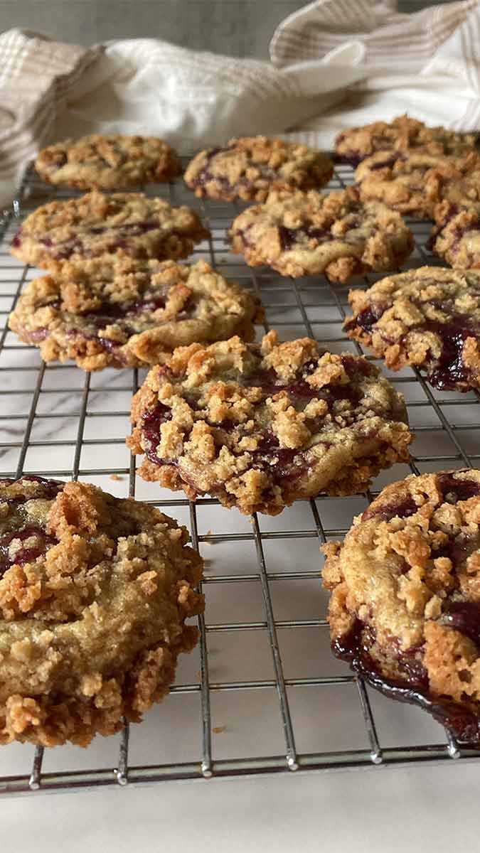 batch of blueberry muffin cookies with streusel topping cooling on a rack