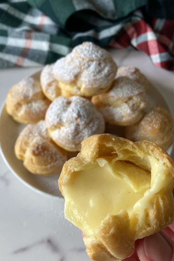 cream puffs with one bite taken out showing filling