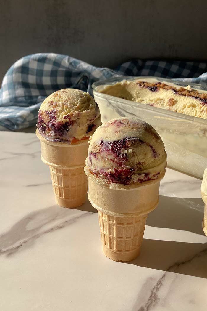 two cones of homemade blueberry streusel muffin ice cream in in the sunshine