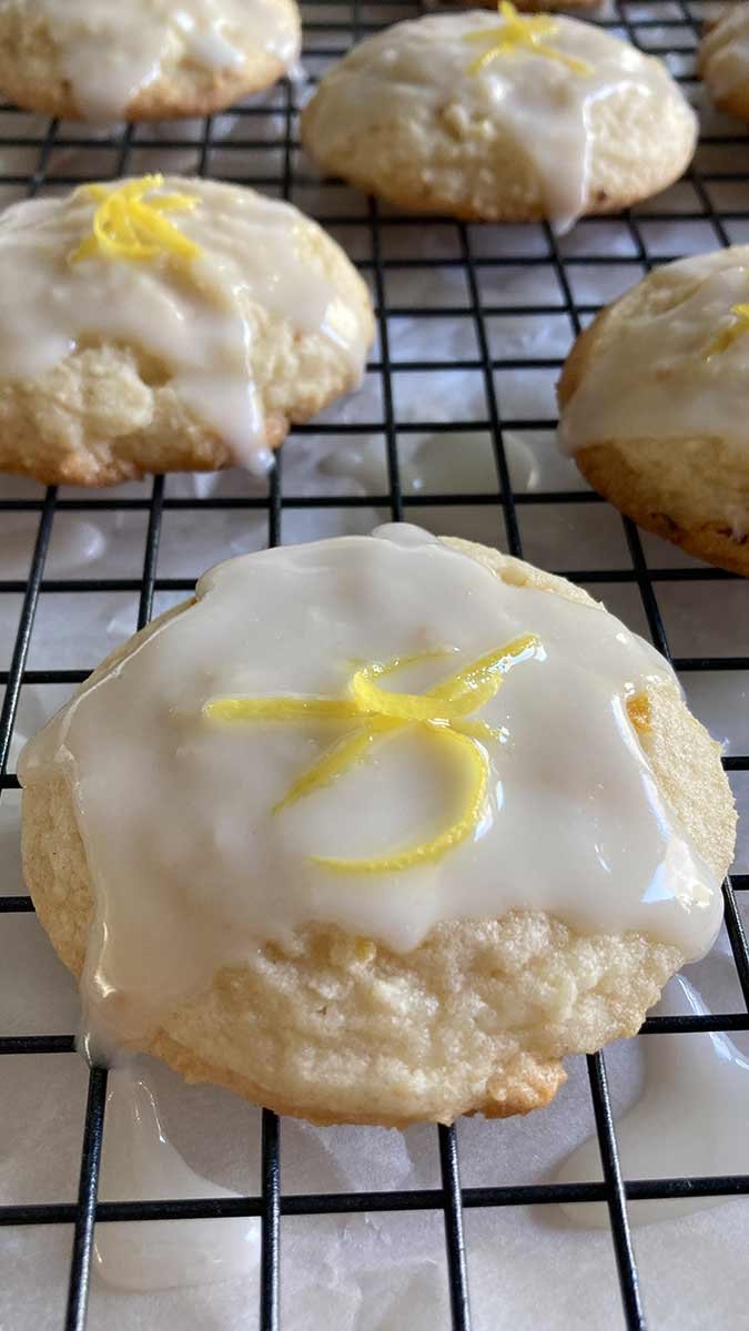 close up of a lemon cookie covered in lemon glaze topped with lemon zest