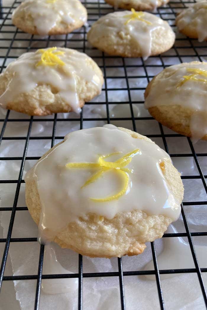 close up of a lemon cookie covered in lemon glaze topped with lemon zest