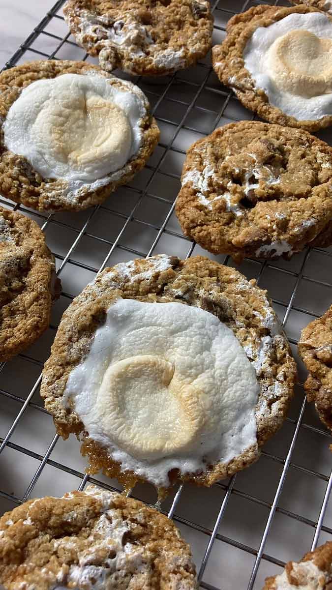 freshly baked s'mores cookies topped with marshmallow on a cooling rack