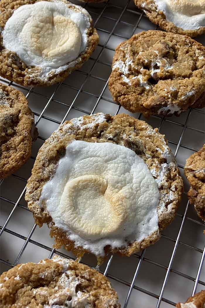 freshly baked s'mores cookies topped with marshmallow on a cooling rack