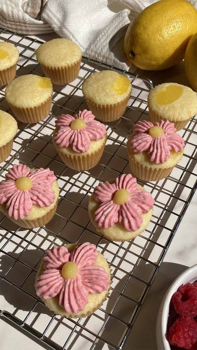 mini raspberry lemonade cupcakes, some decorated like flowers on a cooling rack