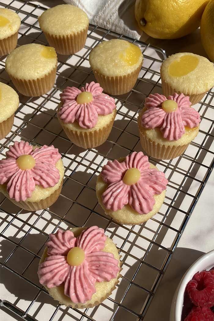 mini raspberry lemonade cupcakes, some decorated like flowers on a cooling rack