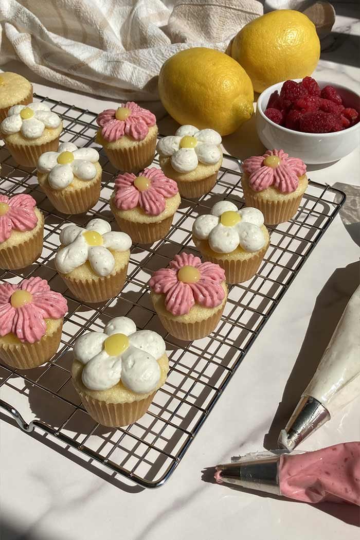 mini cupcakes on a cooling rack, decorated in pink and white flowers