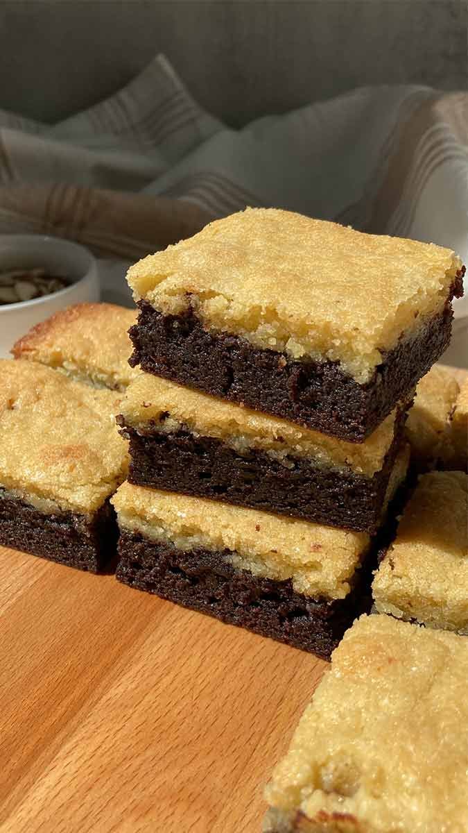 stack of almond frangipane brownies on a wooden cutting board