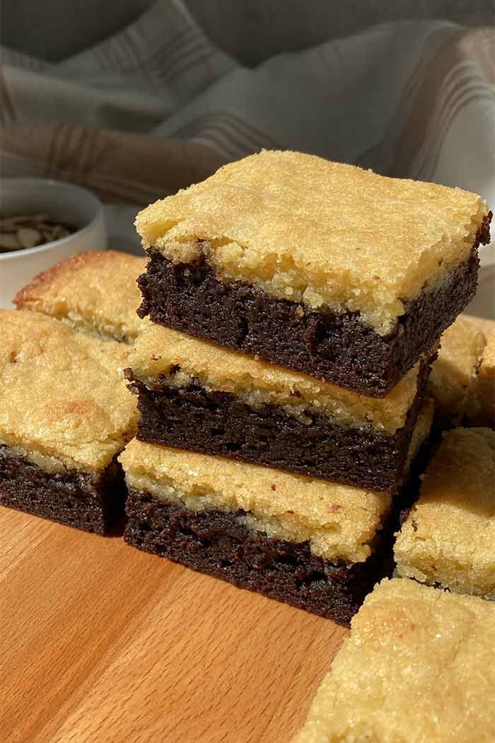 stack of almond frangipane brownies on a wooden cutting board