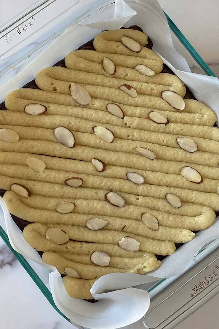 almond frangipane piped on top of brownie batter topped with sliced almonds