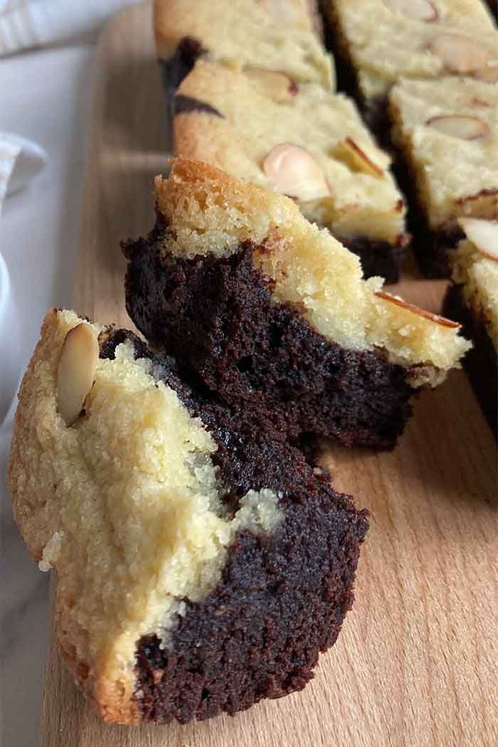 almond frangipane brownie broken in half to show the texture and almond frangipane layer