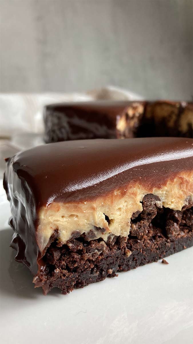 close-up of a slice of peanut butter mousse brownie crunch cake layered dessert