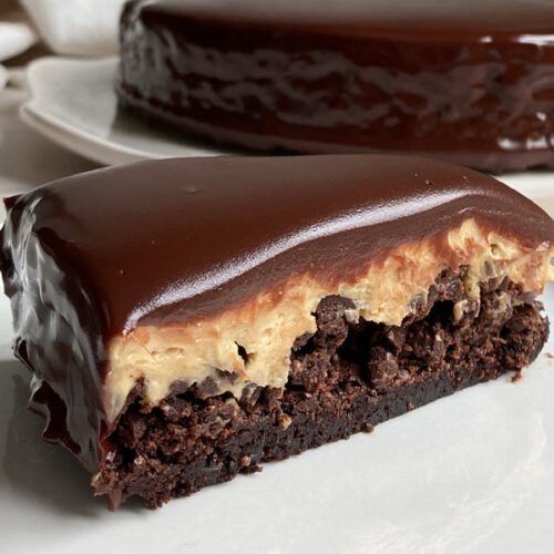 close-up of a slice of peanut butter mousse brownie crunch cake showing each layer