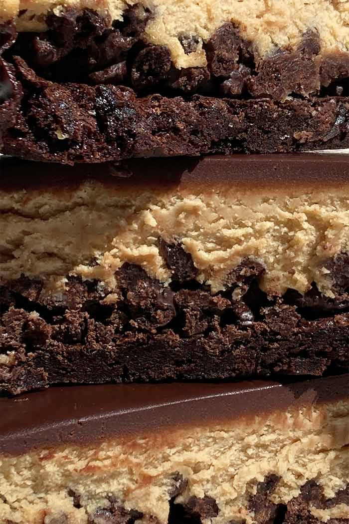 super close-up shot of a stack of 3 slices of peanut butter mousse brownie crunch cake showing the varying textures of each layer